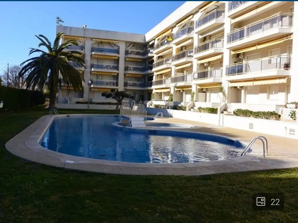 Edificio con piscina y palmeras en primera línea